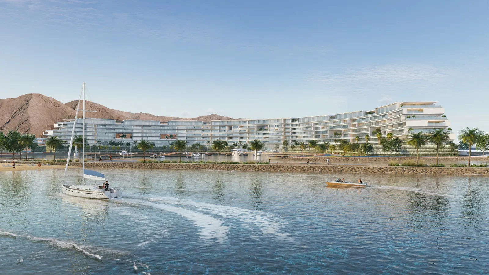 The Arc Residences seen from the water, a low waterfront building with a sailboat passing in front