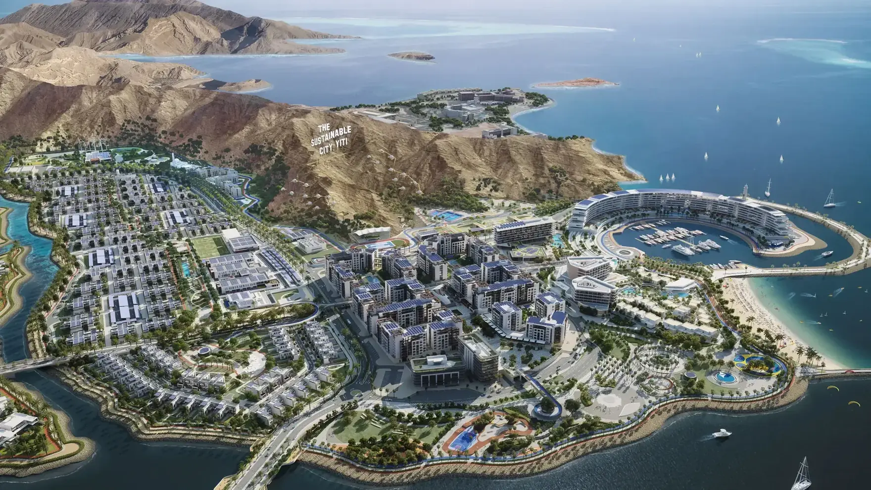 Wide aerial of The Sustainable City, Yiti, set into its bay between the mountains and the sea
